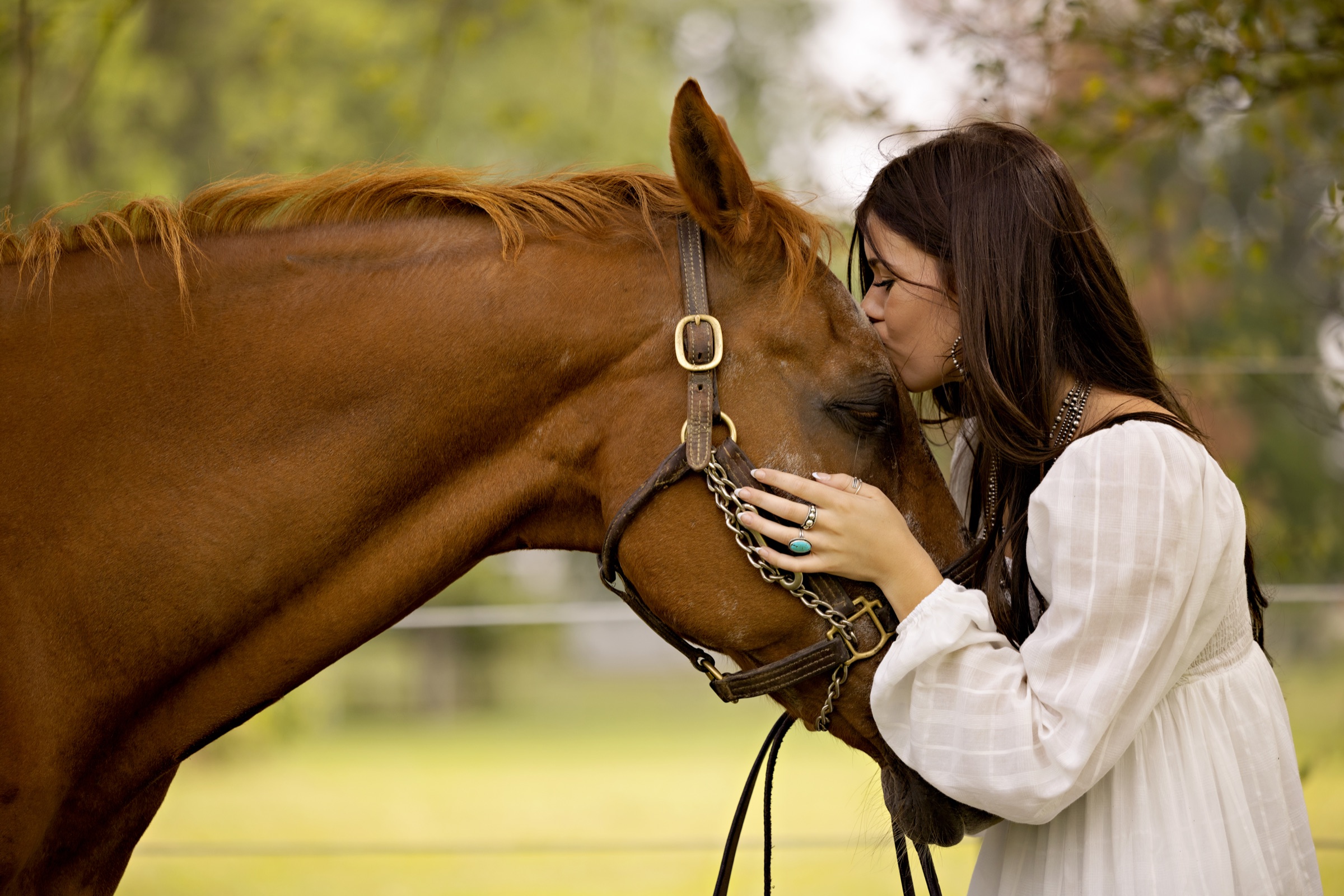 Emma DeJong with two horses at sunset